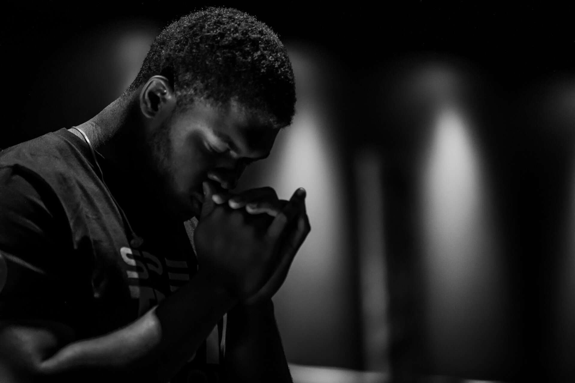 Black and white photo of a man praying